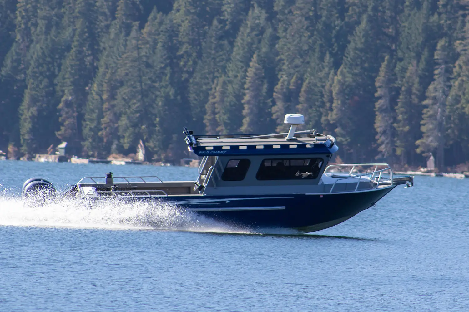 24′ River Hawk Pro cruising past a forested shoreline